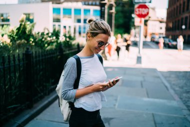 Hafta sonları şehirde harcama cep telefonuna kısa mesaj gönderme arkadaşıyla Sohbet sokak, pozitif kadın turist üzerinde geziniyor şehir merkezinde kafe arama için akıllı telefon kullanan hippi kız gülümseyerek