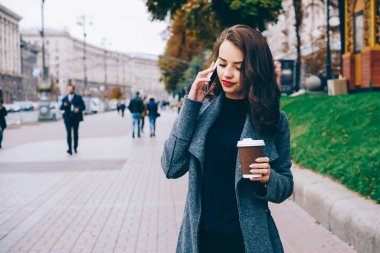 Çekici erkek dijital hücresel kahve ile sokakta el durmuş konuşuyorum. Şık hippi kız açık havada kentsel ayarlarında modern smartphone üzerinden iletişim. Metin için promosyon arka plan