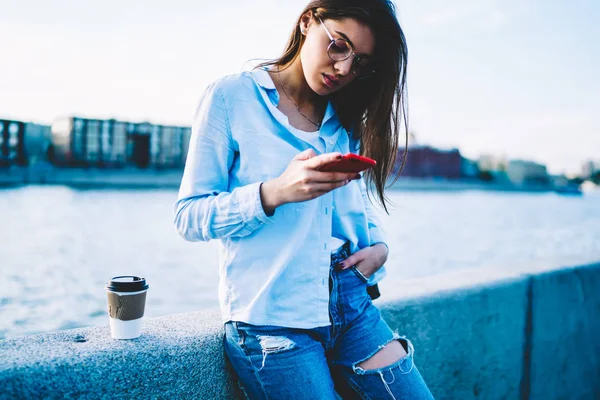 Zamyślony Hipster Dziewczyna Okulary Czytanie Wiadomości Strony Internetowej Smartfonie Odpoczynku — Zdjęcie stockowe
