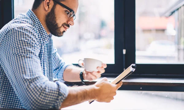 Tilfeldig Kledd Hipster Leser Informasjon Fra Notisboken Mens Han Har – stockfoto