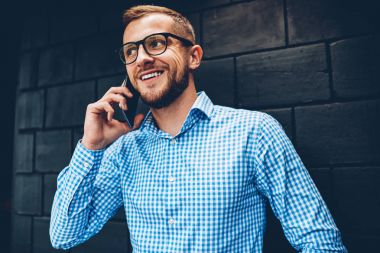 Pozitif işadamı meslektaşı ile telefonda konuşurken proje ile ilgili iyi haber ile çıkıldı tarifeler kapalı, vakit cep telefonu aramalar için gözlük gülümseyen hipster adam memnun