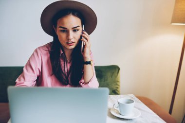 Banka hesabı online kontrol ve müşteri destek operatörü ile telefonla, onu iş üstünde laptop hakkında Haberler okuma mobil konuşmayı genç kadın konuşmaya dalgın kadın serbest meslek