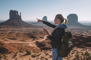 Hippi kız manzara doğa görünümü ortamında smartphone, kadın Gezgin Monument Valley hedefe getting zevk telefonu uygulaması kullanarak tutan Navajo rezervasyon işaret gülümseyen