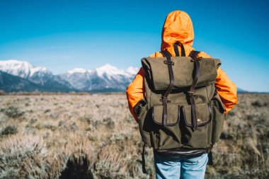 Geniş alanda karla kaplı dağlar ufukta, seyir tatil aktif olarak ABD'de yolculuk sırasında doğa ve çevre keşfetmek harcama hippi kız ayakta sırt çantası ile genç kadın Gezgin