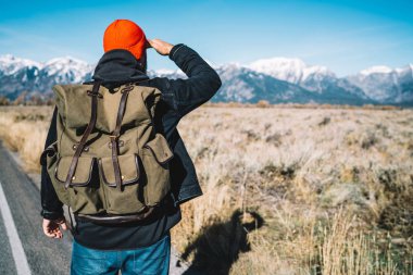 Arkadan görünüşü erkek seyahat tur ABD'de uzakta, dağlar başında seyir hiking sırasında sırt çantası ile vahşi çevre gözlemleyerek ve doğa panoramik manzarayı keşfetmek hipster adam yürüme 