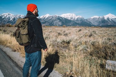 Erkek seyahat tur tatil sırasında ABD, aktif ve dinlenme ufukta dağlar tepeler karlı dorukları seyir sırt çantası adamla hipster hiking sahip peyzaj manzaralı manzarayı