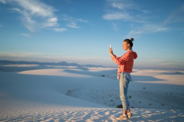 Hippi kız beyaz kum Çölü'Ulusal Anıtı, tam uzunlukta kadın Gezgin selfie Simgesel Yapı keşfetmek telefonu kamera üzerinden alarak güzel manzara fotoğrafları yapma smartphone ile ayakta