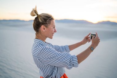 Hippi kız manzara resmini alarak poz selfie smartphone ayakta beyaz kumları Milli Parkı'nda, tarih için genç blogger gülümseyen güzel doğa Yolculuk tutkusu yaz tatillerini zevk gezisi sırasında