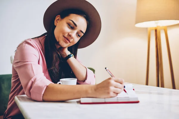 Attraktiv Ung Kvinne Trendy Hatteskriving Dagbok Som Hviler Koselig Interiør – stockfoto