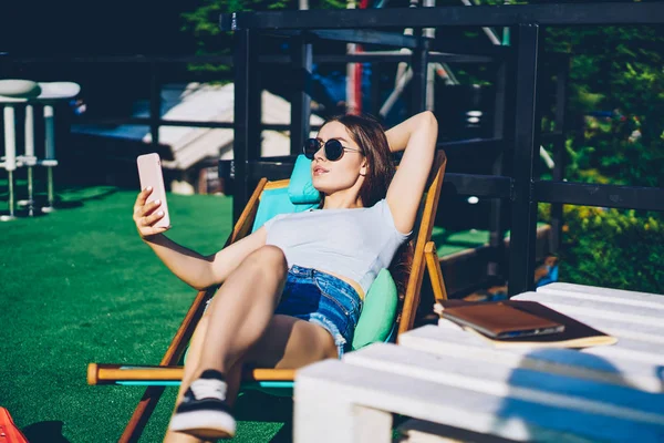 Sevimli Genç Kadın Uzun Saçlı Kamera Modern Smartphone Şezlong Üzerinde — Stok fotoğraf