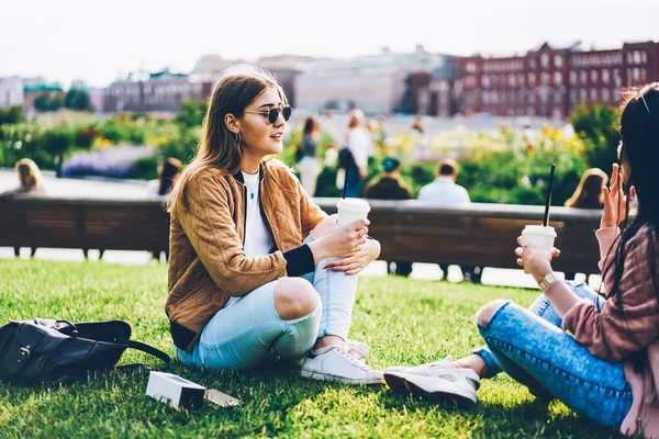 Duas Meninas Hipster Com Café Saboroso Mãos Sentadas Grama Verde — Fotografia de Stock