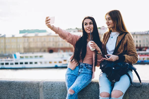 現代の電話立って Selfies 写真を作るスタイリッシュなカジュアルな服で つの美しい様にウィット コーヒーと市広報付近の広告プロモーション背景にバックパック — ストック写真