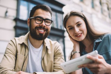 Kameraya gülümseyen neşeli çok kültürlü dostların portresi modern dokunmatik bloknotlar üzerinden e-posta beklerken mutlu çiftler birbirleri için zaman geçiriyorlar. İlişki kavramı.