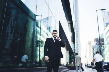 Resmi takım elbiseli bir erkek operatöre cep telefonu uygulaması üzerinden arıyor. Manhattan 'a iş gezisi sırasında uluslararası sohbetler için gezinti tarifeleri kullanıyor. Açık hava iletişimi kavramı.