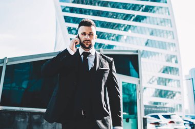 İş ortağıyla yapılan akıllı telefon görüşmeleri sırasında resmi olarak kameraya bakarak ve finansal haberleri tartışarak gururlu CEO uzmanının yarım boy portresi, iletişim konsepti