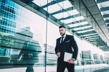 Yakışıklı beyaz iş adamı, modern dizüstü bilgisayarla kendi şirketine online finansal strateji oluşturmak için yönetim uzmanına gidiyor. 30 'larında ciddi bir erkek lider şehir merkezine gidiyor.
