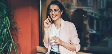 Neşeli hippi kız şakadan gülüyor. Arkadaşça bir cep telefonu sohbeti sırasında dışarıda mutlu bir İspanyol kadın cep telefonu uygulaması üzerinden ararken gezinti bağlantısının keyfini çıkarıyor.