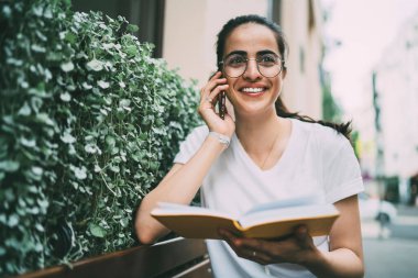 Mutlu kız öğrenci, üniversiteden yaz edebiyatı hakkında konuşmak için en iyi arkadaşına sesleniyor. Kadın okuyucu, en çok satanlar listesi hakkında duygusal olarak uluslararası internet kullanarak konuşuyor.