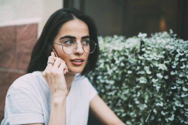 Optik gözlüklü güzel bir kadın cep telefonu ile ilgileniyor. İspanyol hippi kız dedikodu dinlerken 4G hakkında konuşmak için en iyi arkadaşına telefon ediyor.