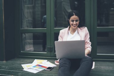 Başarılı bir bayan grafik tasarımcısı, internette internetli dizüstü bilgisayarlarda yaratıcı fikirler hakkında özel ders izliyor, olumlu öğrenci internet üzerinden iş haberleri okuyor ve aynı zamanda derslerle öğreniyor.