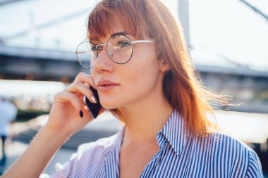 Bin yıllık klasik gözlüklü yeniyetme kızın kapanışı güneşli bir günde telefon konuşmalarına yoğunlaşması ve danışmanlık için akıllı telefon uygulaması aracılığıyla derin düşüncelere sahip bir kadın araması.