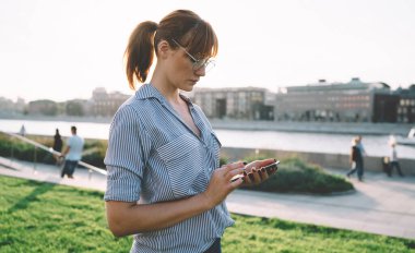 İnternette gezinmek için 4G kablosuz bağlantısını sosyal ağlarda yayınlamak için metin içeriği yazan çekici bin yıllık blog yazarının yan görünümü, web sayfasında kullanıcılarla sohbet eden güzel bir kadın