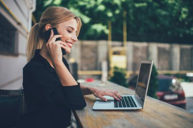 Çevrimiçi alışveriş yapan neşeli bir kadının internet sitesindeki iletişim numarasını araması ve modern cep telefonuyla telefonla araması, iş arkadaşlarıyla konuşurken uzaktan çalışan pozitif kadın serbest yazar.