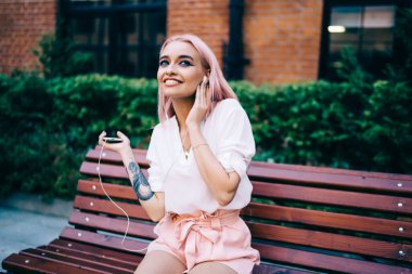 Heyecanlı, pembe saçlı, açık havada dans eden ve favori müzik parçalarını dinleyen genç bir kız. Mutlu hippi kız, iyi ses şarkılarından, milenyum insanlarından zevk alıyor.