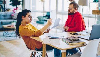 Düşünceli bir kadın, ev içi ilişkilerde kocasıyla birlikte finansal raporlardan elde edilen bilgileri analiz ediyor. Düşünceli iş arkadaşları, masa başında oturan projeye çözüm bulmaya odaklanıyor.