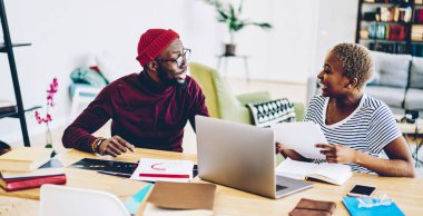 Pozitif Afro-Amerikalı meslektaşlar masaüstündeki üretken çalışma sürecinde yaratıcı fikirler hakkında tartışıyorlar, mutlu öğrenciler Fla 'da öğrenme ve iletişim projesini birlikte hazırlıyorlar.