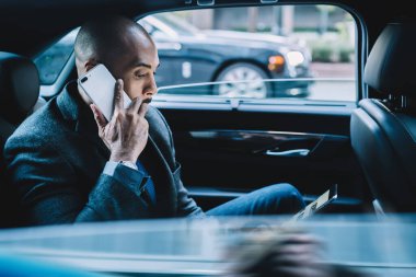 Resmi takım elbiseli ciddi bir komisyoncunun resmi e-postasını okuması ve detaylar için uluslararası cep telefonu araması yapması. Koyu tenli bir adamın telefon görüşmesi ve sohbet için 4 G 'yi kullanması.