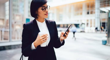 İş yerindeki kahve molası sırasında cep telefonuyla veri servisi hakkında bilgilendirme okuyan genç esmer kadın, internet sitesinde finans haberleri okuyan bin yıllık kadın avukat.