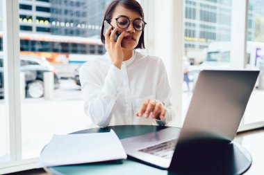 Konsantre kadın tüccar yeni başlangıç projesi için bilgi ararken aynı zamanda akıllı telefon aygıtında iletişim kurmak için 4G bağlantısı kullanarak ortakları da arıyor.