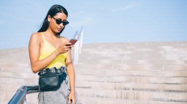 Çekici bin yıllık kadın blogcu İnternet kullanımı hakkında metin yayınları yaratıyor, İspanyol kadın şehir ortamında 4G kablosuz bağlantıya bağlı akıllı telefon uygulaması bildirimini kontrol ediyor