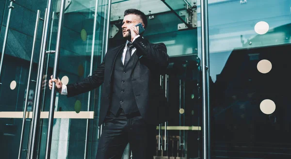 パートナー企業で企業会議に行く間 携帯電話のアプリケーションを介して通信する高級スーツのエレガントな銀行家 Gローミングを使用してスマートフォンを介して話すインテリジェントな男の誇りCeo — ストック写真