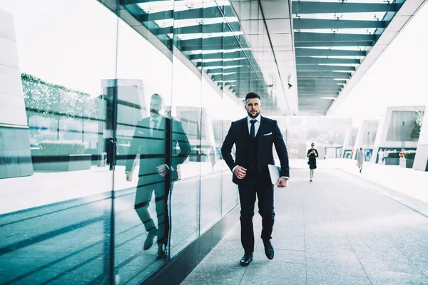 深刻な自信を持って男性弁護士は オンライン貿易ビジネスのための近代的なラップトップコンピュータを保持ダウンタウンで歩くエレガントな高級スーツを身に着けています 若いオフィスの男は 企業でプレゼンテーションに行く — ストック写真