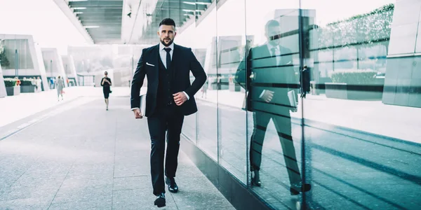 現代的なネットブックを手に市内を歩く会社の自信の男性の所有者 深刻な白人ビジネスマンは 金融地区の企業会議に行く正式な高価なスーツ姿 — ストック写真
