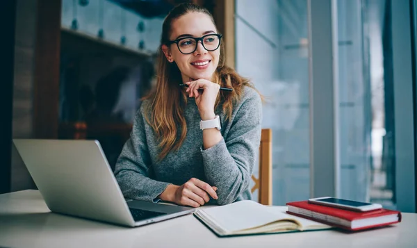 ノートパソコンを使って机に座って勉強し 眼鏡をかけている若い女性が勉強中に良い仕事をすることに成功し 成功した女性学生 — ストック写真