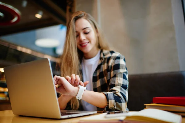 Estudante Feminina Positiva Verificando Tempo Smartwatch Eletrônico Wearable Enquanto Sentado — Fotografia de Stock