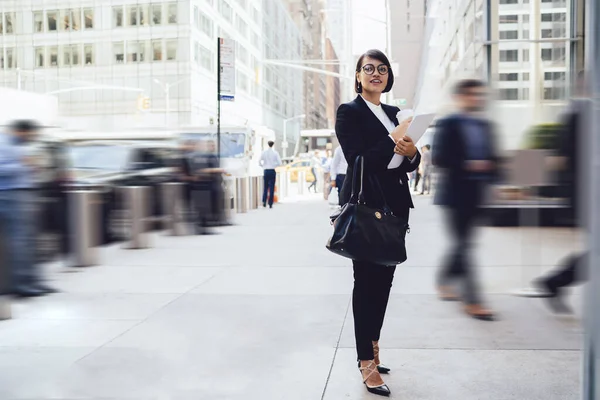 都市部の設定に立って視力矯正のための眼鏡の正の女性と離れて見てエレガントなスーツでビジネスパートナー 幸せな女性経済学者と会う前に仕事の休憩を楽しむ — ストック写真