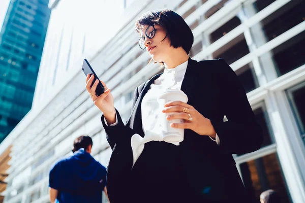 Manhattan 'da finans dünyasıyla ilgili haberleri okumak için kahvenin altında iş molası sırasında şehrin sokaklarında duran çekici bir kadın hücresel bağlantıda 4G kullanıyor.