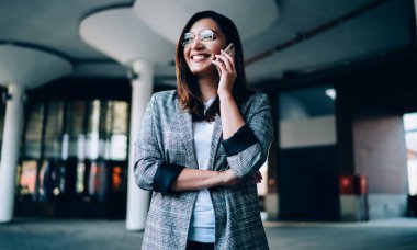 Gözlüklü gülümseyen, telefonla telefonla konuşan, cep telefonundan memnun olan, akıllı telefon konuşmalarında iyi haberler alan, mutlu hippi kız.