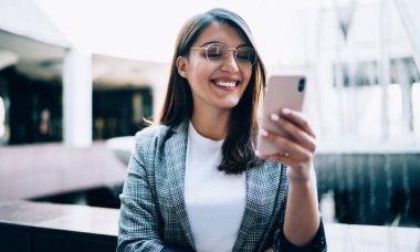 Geleceğin komedi fragmanını izlerken gülümseyen mutlu kadın film sitesi için 4G kablosuz bağlantısını kuruyor, neşeli genç blogcu takipçileriyle grup sohbetinde mesajlar alıyor