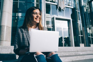 Uzaktan kumanda sırasında gülümseyen gözlüklü, vizyon düzeltme gözlüklü yetenekli kadın serbest yazar, olumlu Türk metin yazarı