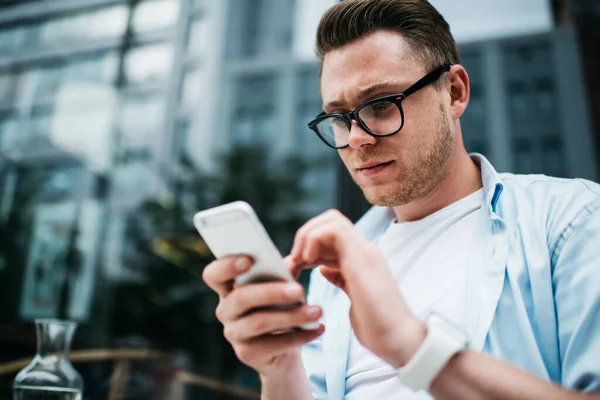 Zdola Pohledný Běloch Černých Brýlích Košili Surfování Smartphone Zatímco Sedí — Stock fotografie