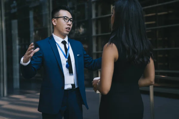 Joven Asiático Traje Gafas Hablando Con Compañera Trabajo Étnica Reunión —  Fotos de Stock