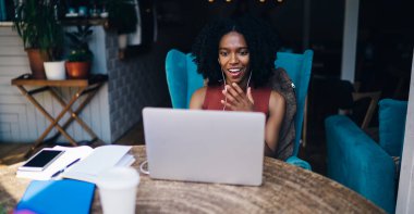 Mutlu koyu tenli hippi kız internet sitesinden gelen motivasyonlu bilgilere şaşırmış durumda. Netbook 'a müzik çalma listesi indirdiği için yüksek hızlı internet bağlantısından şoke olmuş durumda.