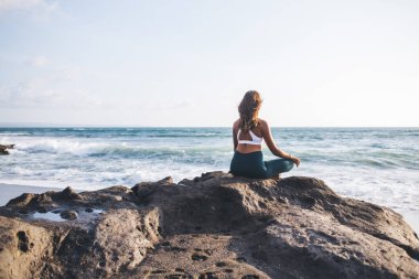 Esmer tenli bir kadının yeniden canlandırma için denge kurması ve kendi zihinlerinde huzur ve çakra bulması, rahatlama uyumu ve Endonezya Bali Denizi yakınlarında ruhsal süreç kavramı.