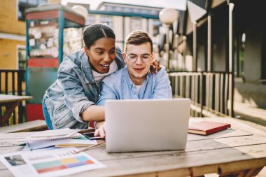 Coşkulu Afrikalı Amerikalı kız, internet sitesinde iyi yorumlar almaktan heyecan duyan Kafkasyalı iş ortakları ve dizüstü bilgisayarla işaretleri kontrol ettiği için iyi bir puan alıyor.