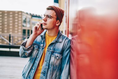 Kafkasyalı hippi adam modası geçmiş kıyafet ve gözlüklerle gezerken cep telefonu sohbeti yapıyor, genç bir erkek akıllı telefondan kafasını çeviriyor ve arkadaşlarıyla şehir setinde vakit geçiriyor.